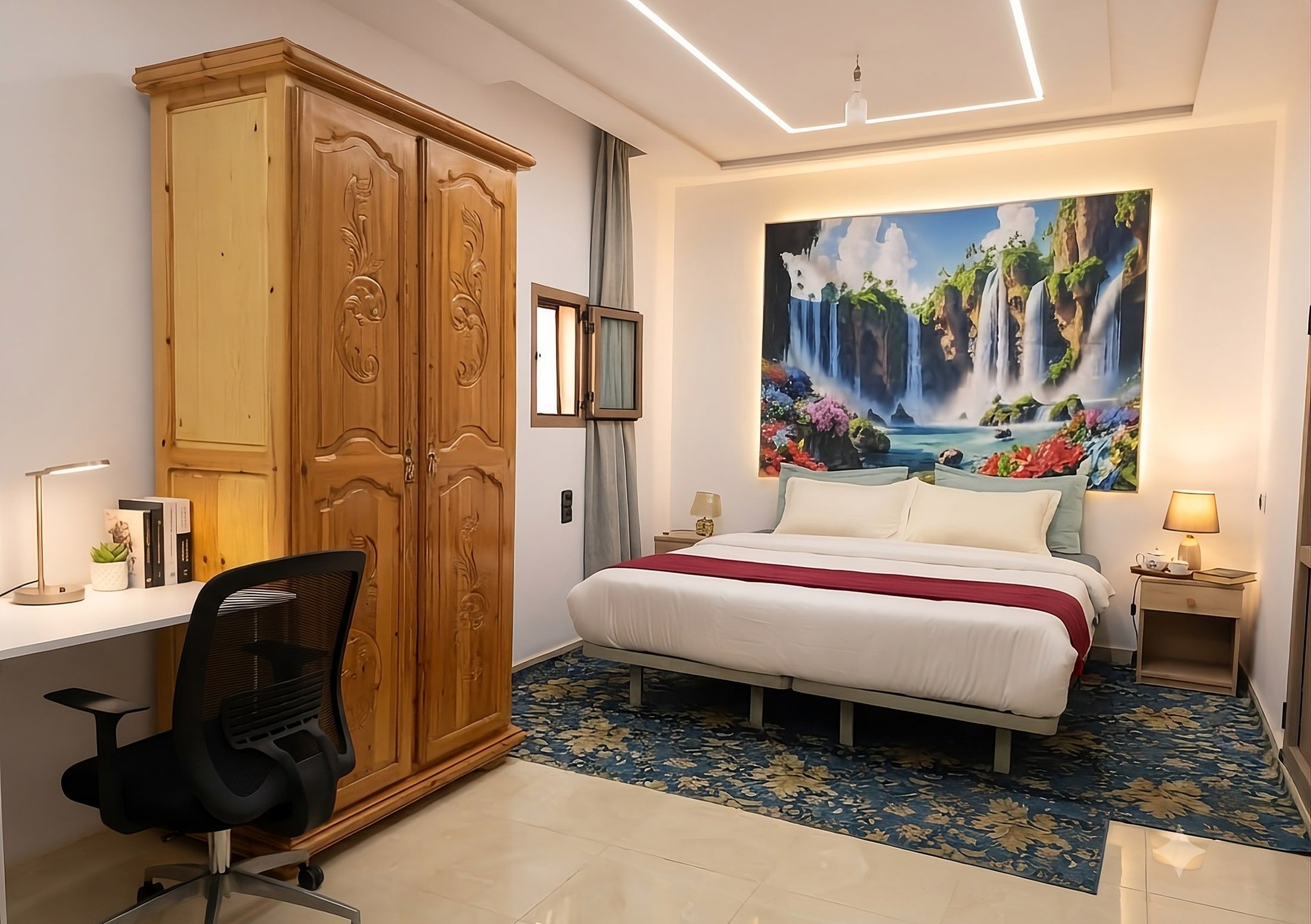 A private room at Aziz House with a double bed, carved wooden wardrobe and a desk