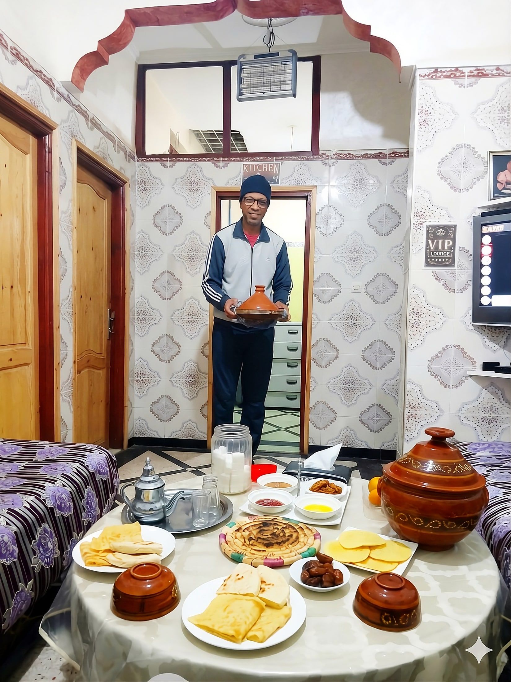 Aziz serving a Moroccan breakfast in the shared lounge at Aziz House